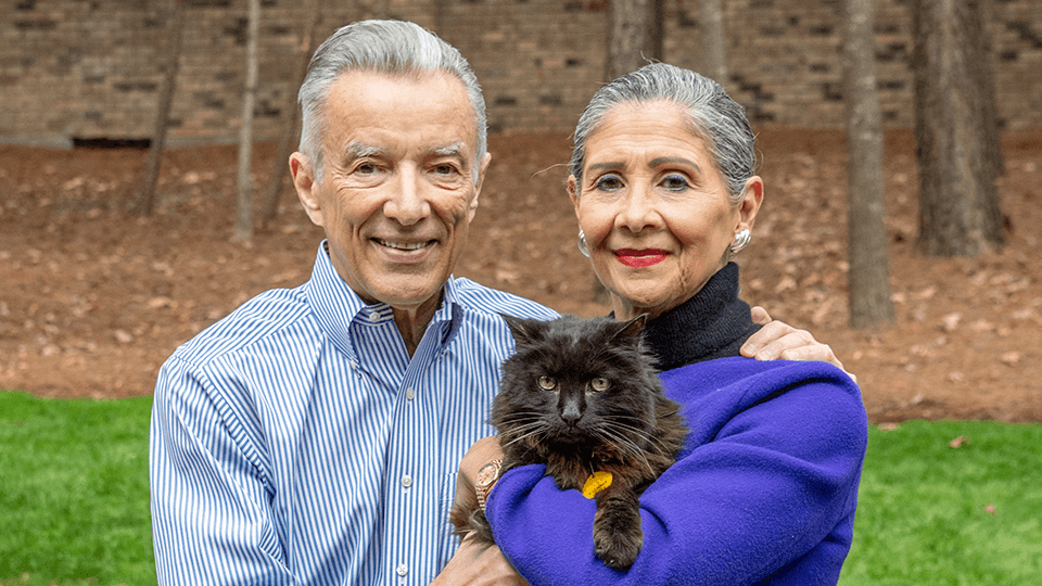 A couple smiling with their cat