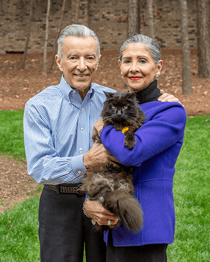 A portrait of a couple smiling with their cat